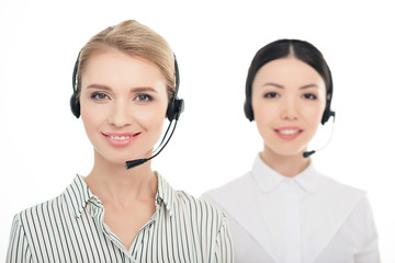 portrait of smiling call center operators in headsets isolated on white