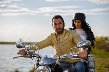 Fototapeta na wymiar Beautiful young couple with a classic motorcycle