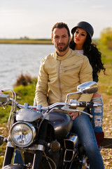 Beautiful young couple with a classic motorcycle