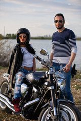Beautiful young couple with a classic motorcycle