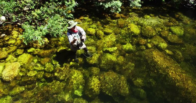 Fisherman fly fishing in river