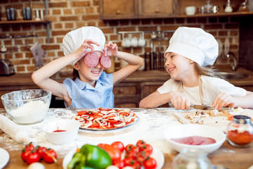 kids in chef hats having fun while making pizza