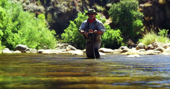 Fisherman fly fishing in river