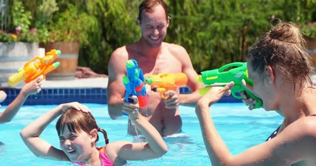 Happy family doing water gun battle in swimming pool - Powered by Adobe