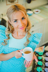 young blond woman drinking tea in the kitchen