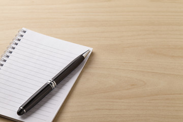 Note book and pen on the wooden table