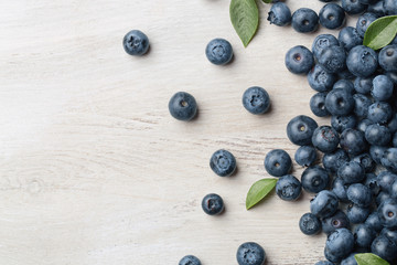 Freshly picked blueberries spilled on the wooden background with copy space