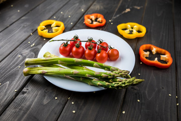 Close-up view of fresh seasonal vegetables on plate on wooden table background