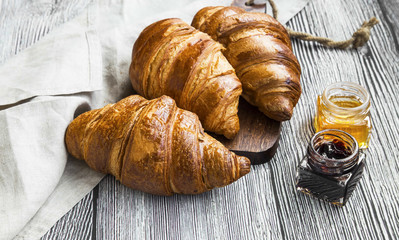 Croissants bakery, french buttery pastry with ham jars on wooden background