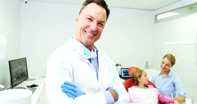 Dentist standing with arms crossed in clinic