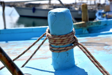 cleat with rope on blue fishing boat  
