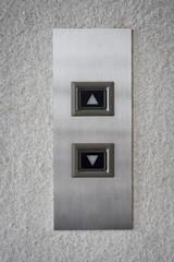 The modern lift button panel on stone tite wall close up background.