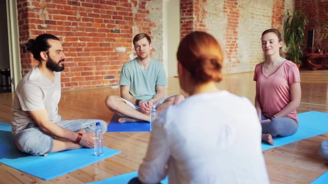 group of people resting on yoga mats in gym