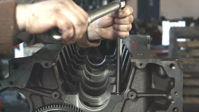 Mechanic working with diesel engine. Engine repair close up. In hands tool.