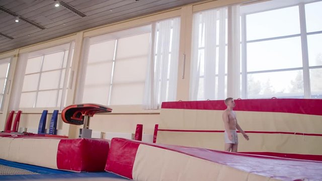 Gymnast training gymnastic somersault exercise HD video. Athlete acrobatic vault performing: handspring, hand salto, flip