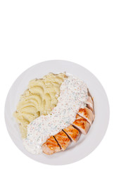 Sliced fried chicken fillet in a creamy and mustard sauce with mashed potatoes. top view. isolated on white