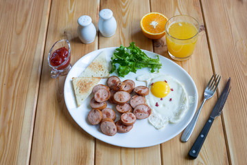 Orange juice, Two eggs and sausage for healthy breakfast.