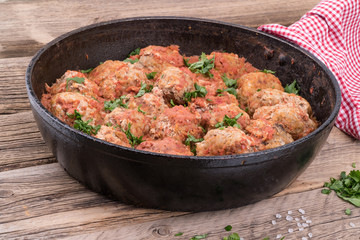 meat balls with herbs in pan on wooden rustic background. Selective focus.