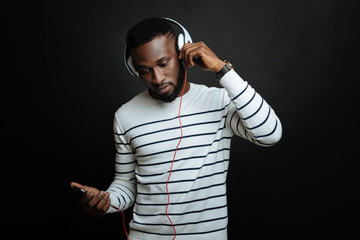 Involved African American man using modern gadgets in the studio