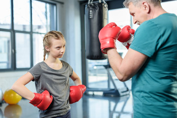 preteen girl boxing with senior trainer. Fitness manager, gym class kids concept
