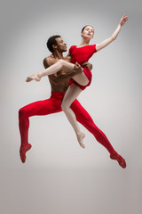 Naklejka premium Couple of ballet dancers posing over gray background
