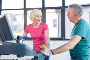 Fototapeta premium old sport couple training on treadmill in fitness class for senior people