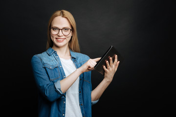 Smart woman demonstrating tablet indoors