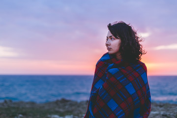 girl in the sunset with blanket on 