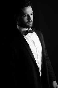 Black and white photography of a man wearing a tuxedo 