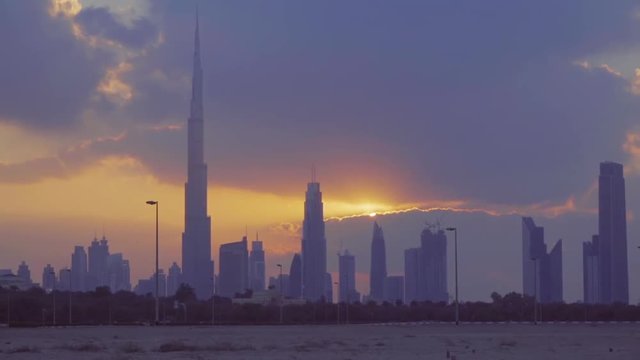 Sunset of Dubai cityscape twilight skyline HD timelapse video from Arabian desert. City skyscrapers modern buildings