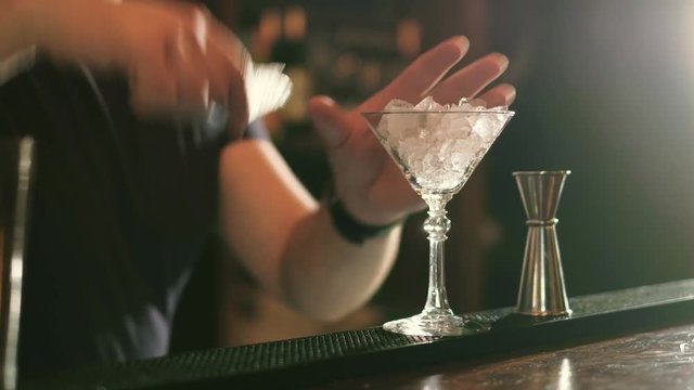 The barman is preparing a cocktail in the night club bar 4k