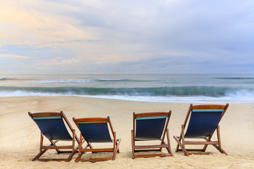 beach chairs on the sandy beaches for tourists to sit and relax with soft ocean waves breaking on beach