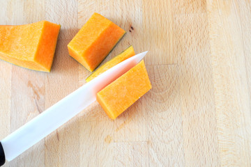 Ceramic knife removes the peel to a slice of pumpkin