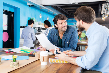 Man reading document business people colleagues working diverse mix race group casual wear modern office businesspeople sitting desk