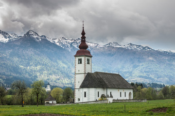 Fototapeta na wymiar catholic church in field among Alps