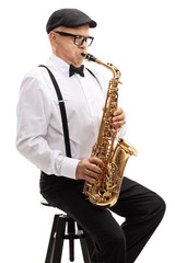 Plakat Elderly saxophonist sitting on a chair and playing