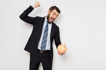 elegant man with piggy bank on white background