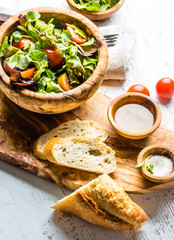 Vegetarian lettuce tomatoes salad in olive wooden bowl