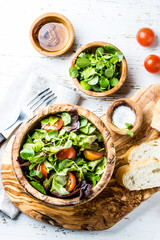 Vegetarian lettuce tomatoes salad in olive wooden bowl