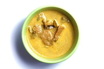 Pork yellow curry with turmeric powder in green bowl represent Thai’s cuisine and spicy curry with real southern Thai traditional food style.
