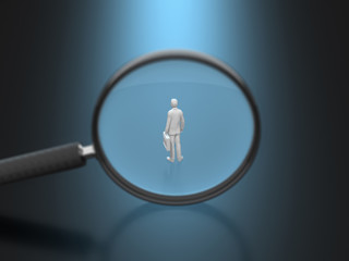 Business figure reflected on the magnifying glass