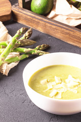 Cream soup of asparagus with cream on a black background, soft focus, vertical

