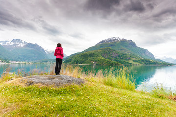 Woman tourist relaxing on fjord sea shore, Norway