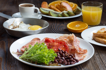 Full English breakfast with sausage, baked tomato, beans and toasts