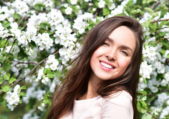 Happy young woman  in a flowering spring garden. Spring time. Flowers blossoms.