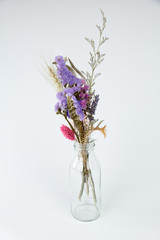 Dried flowers in a bottle isolated on white background
