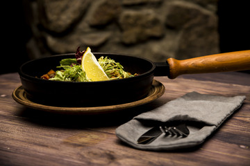 seafood saute served in a small skillet with a slice of lemon