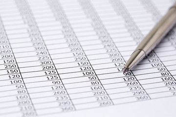 Close up a silver pen on financial accounting and marketing table analysis