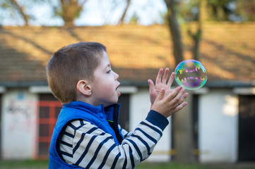 little boy catching bubble outdoor