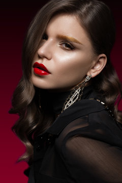 Beautiful girl with red lips and golden eyebrows, curls in Hollywood style. Beauty face. Photo taken in the studio.